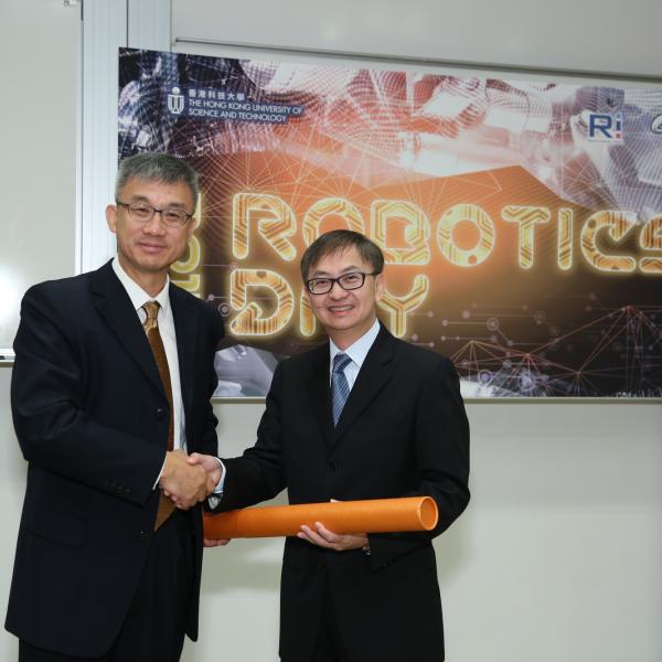 Prof Michael Wang (left) presenting a souvenir to Dr David Chung.