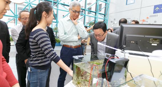 （右起）科大（广州）校长倪明选教授及科大校长史维教授参观2019年11月举行的SSC展览，了解如何利用微型水族馆的植物发电。