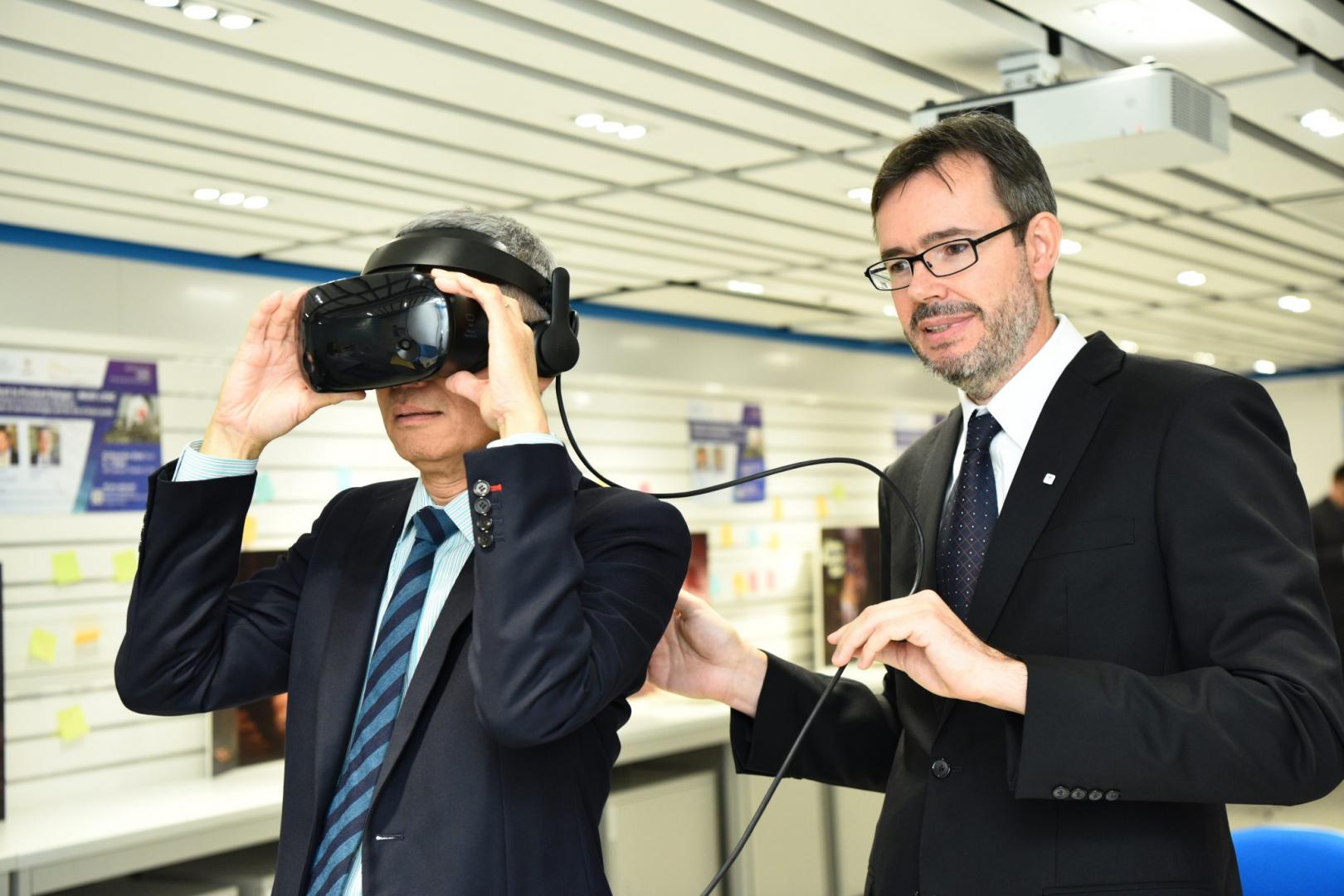  史维教授于展览上试戴ICRC用以训练员工而设的虚拟现实装置。