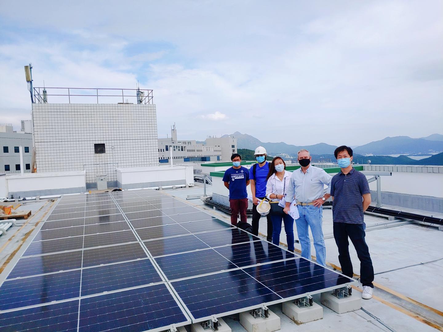 Bookhart (second right) with the project team on the roof of Tower C, Lo Ka Chung University Center, with solar panels newly installed.