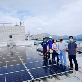 Bookhart (second right) with the project team on the roof of Tower C, Lo Ka Chung University Center, with solar panels newly installed.
